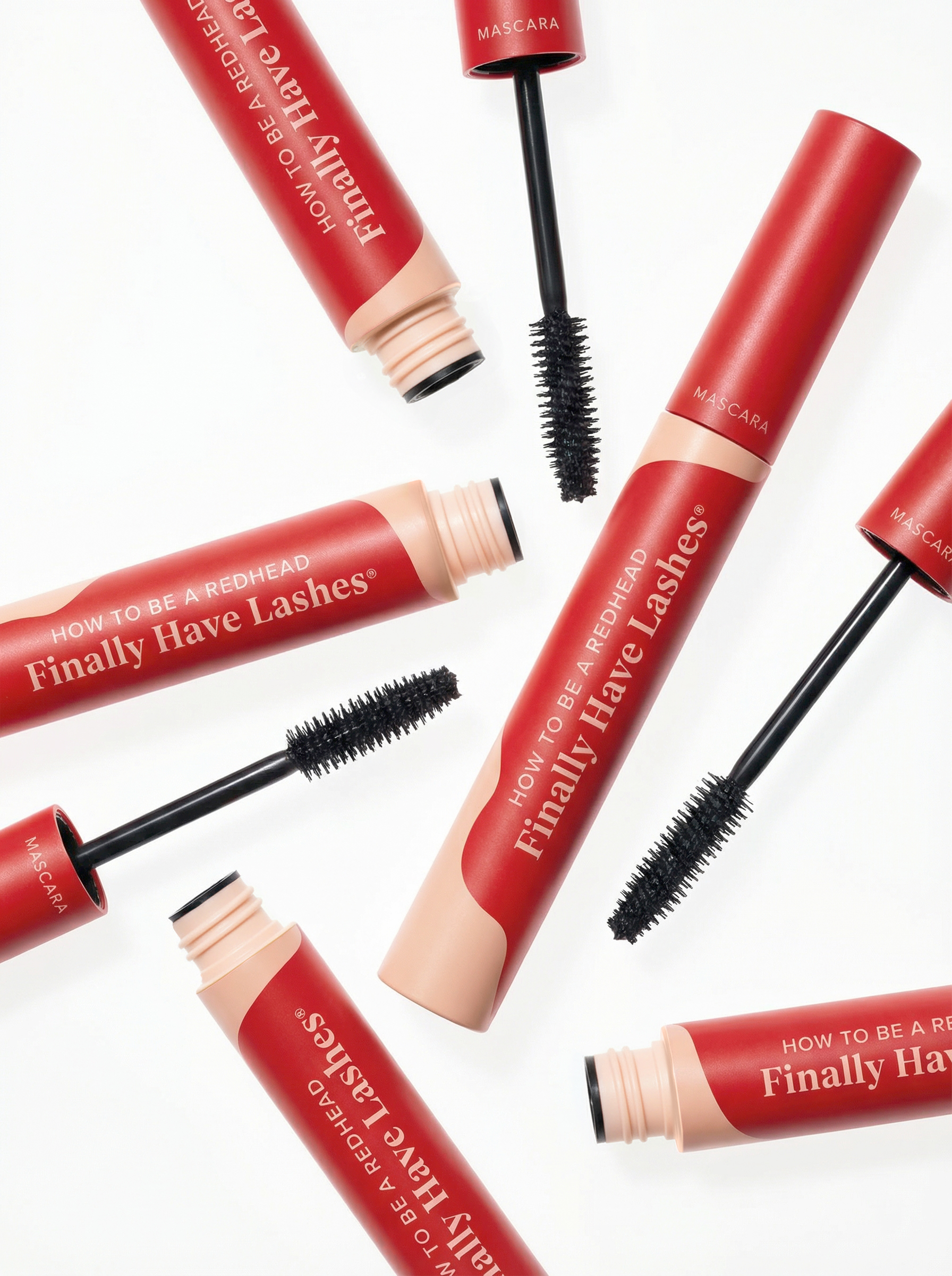 Overhead flat-lay of scattered mascara tubes and wands